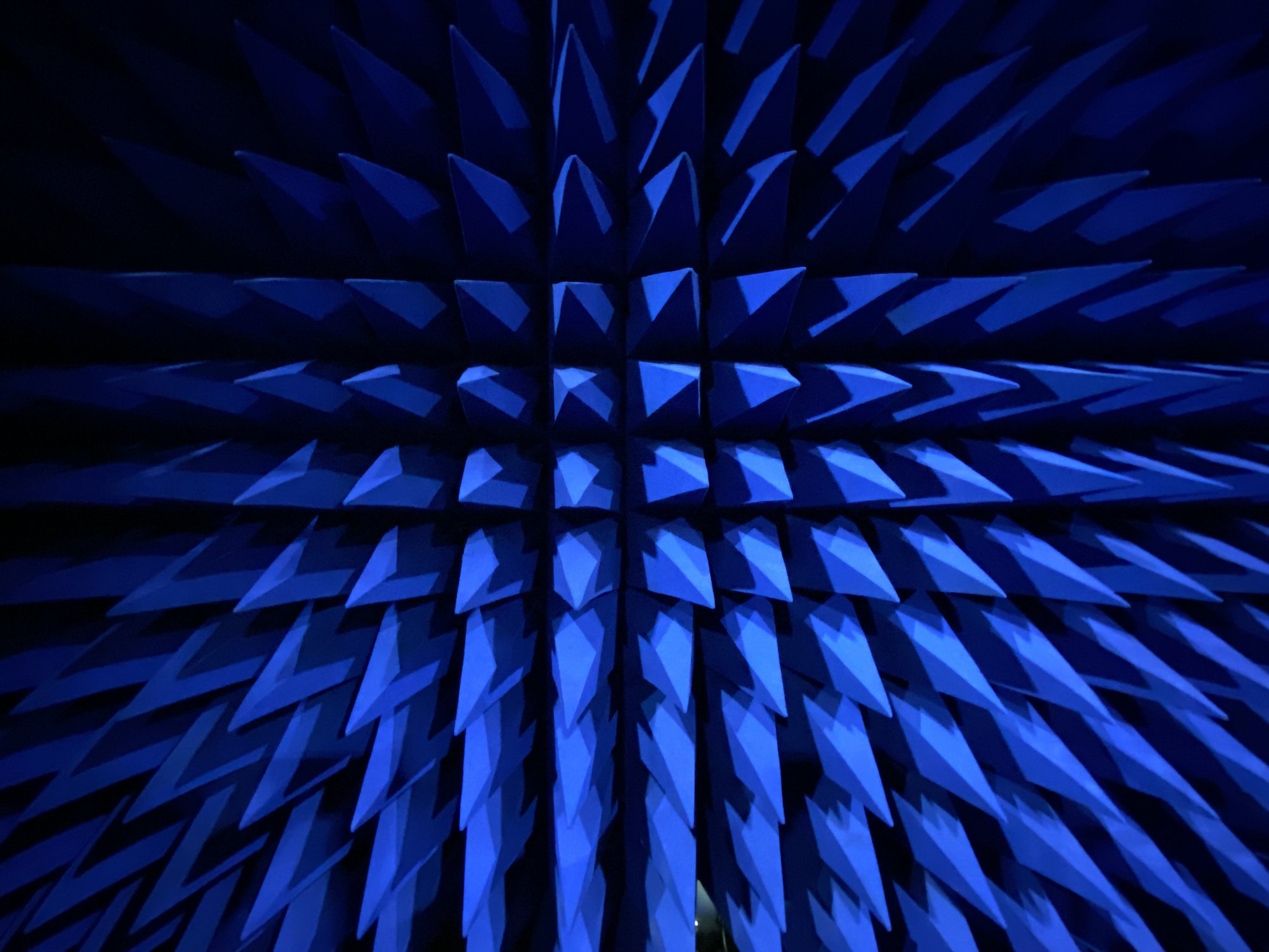 Close view of the blue pyramid-shaped radio-frequency absorbers lining the wall of the anechoic test chamber at LabTest Certification.