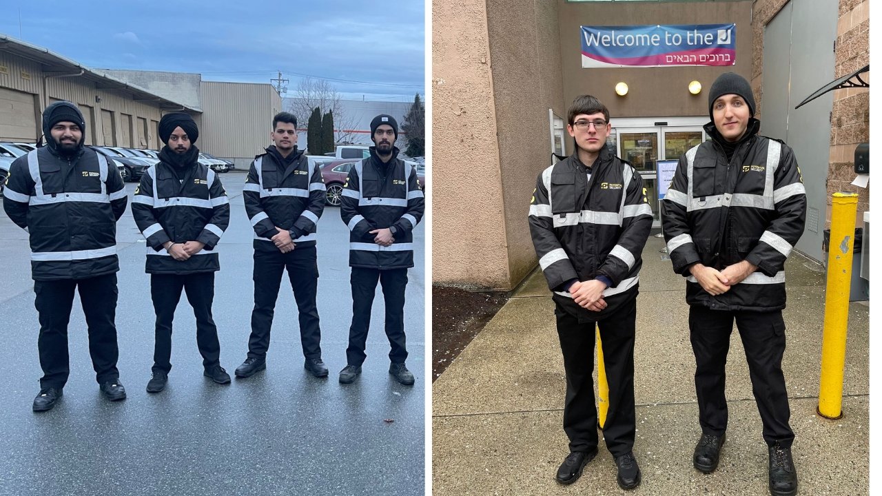 Potential Security guards in black insulated jackets with reflective banding, four lined up in a parking lot and two posted at a building entrance beneath a welcome banner.