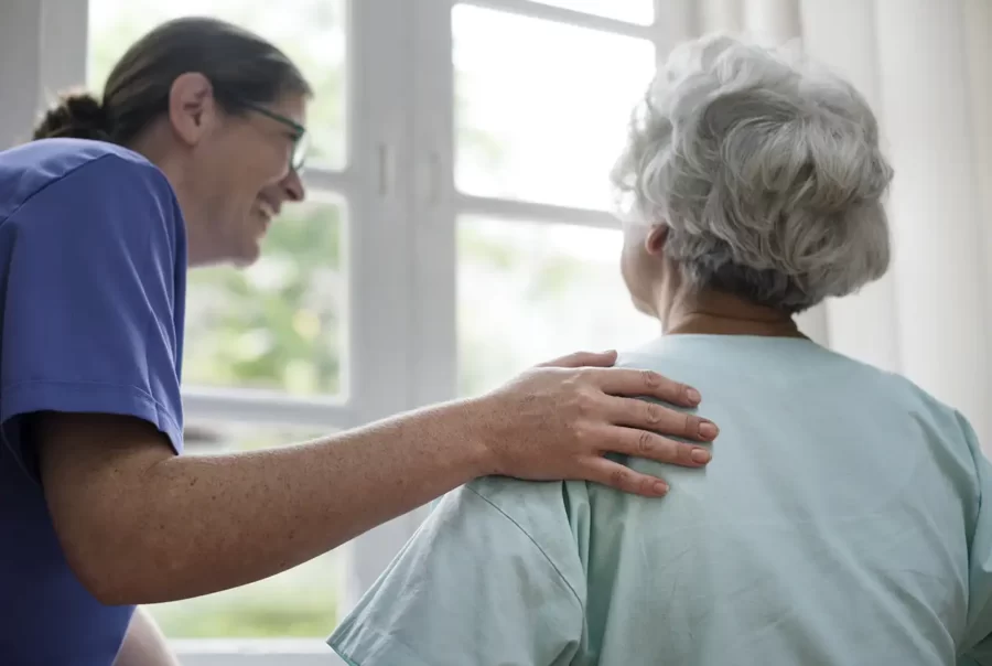 A Guarding Life Home Care caregiver sitting with a client during a home visit.